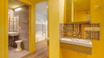 Une salle de bain avec un lavabo blanc, des toilettes et un espace douche.