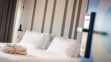 Una habitación de hotel con cama, almohadas y bata.