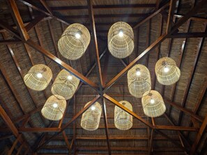 Techo con estructura de madera geométrica y varios apliques tejidos.