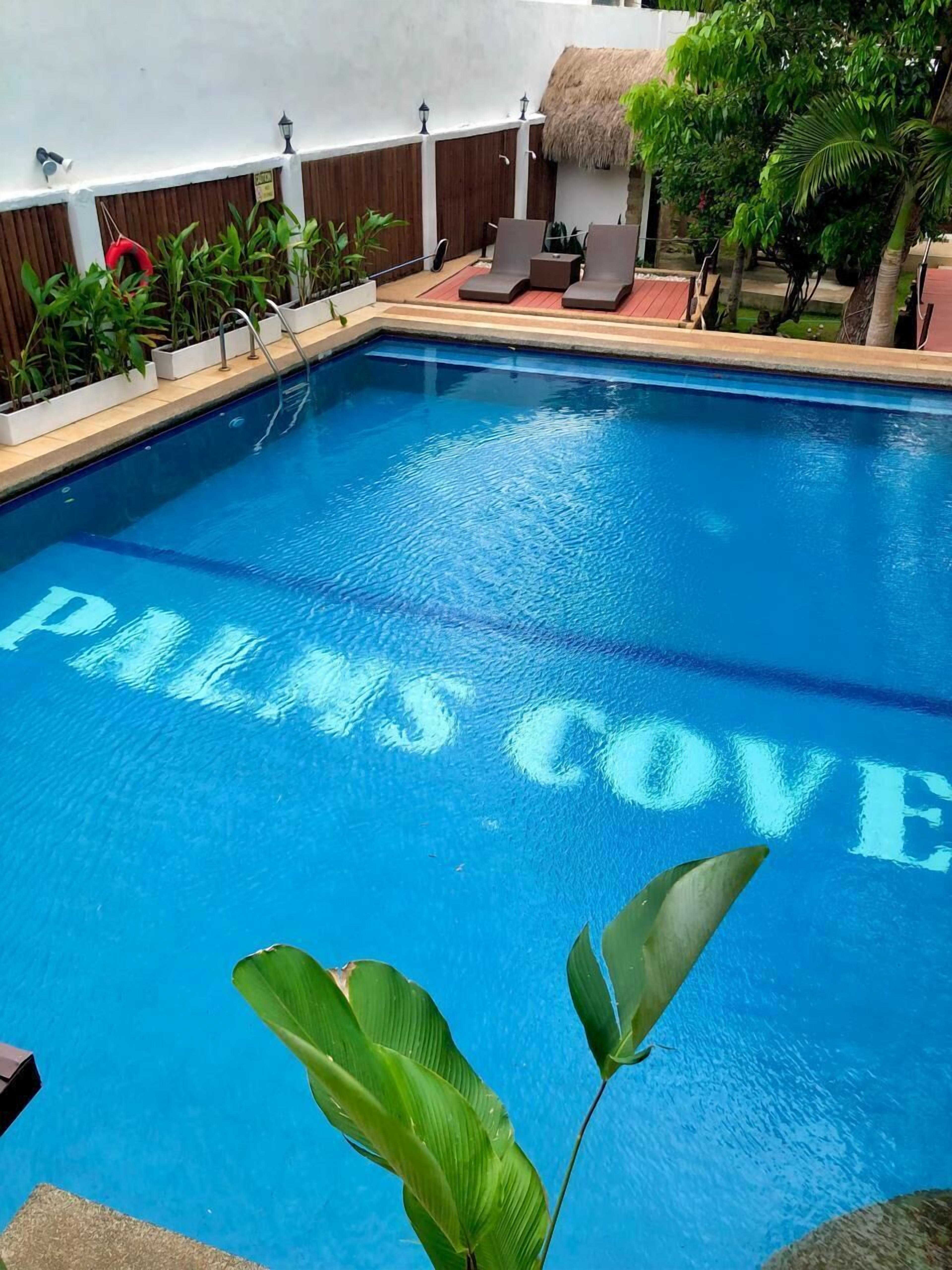Una piscina con las palabras "PALMS COVE" escritas sobre el agua.