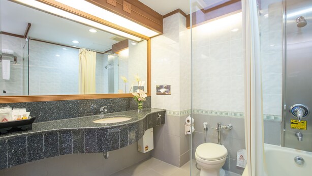 A modern bathroom with a granite countertop, a glass shower enclosure, and a white toilet. - Asia Cha Am Hotel (Cha-am)