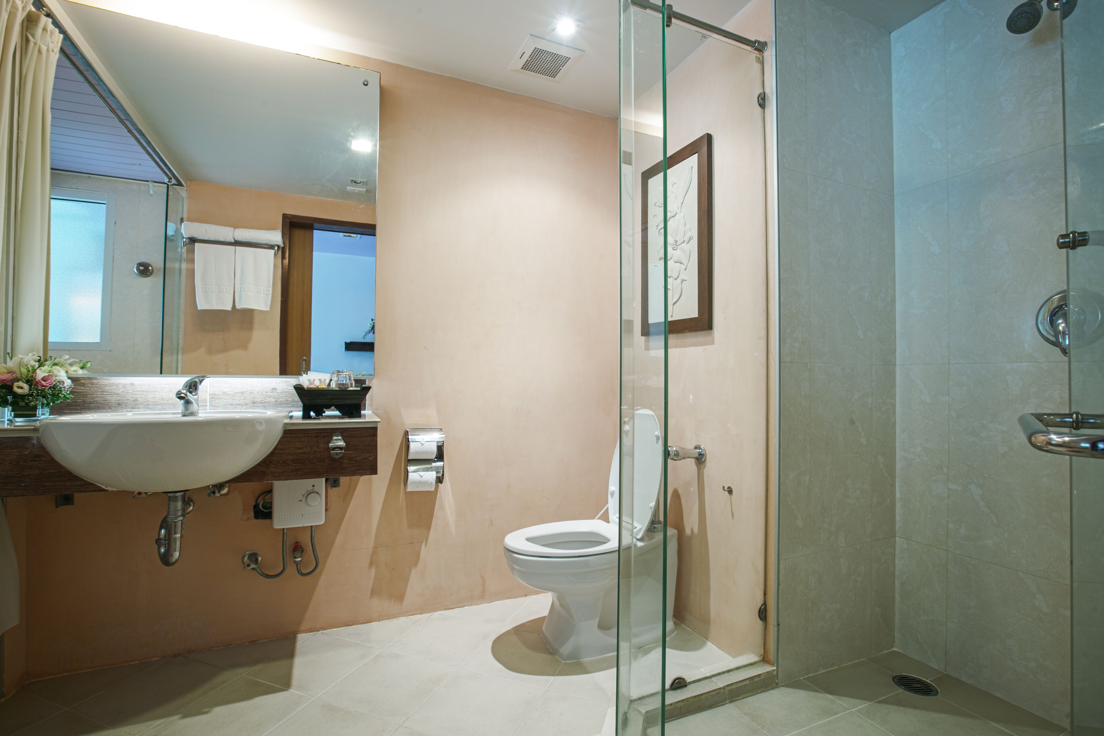 Une salle de bain avec une douche à parois de verre, un lavabo et des toilettes.
