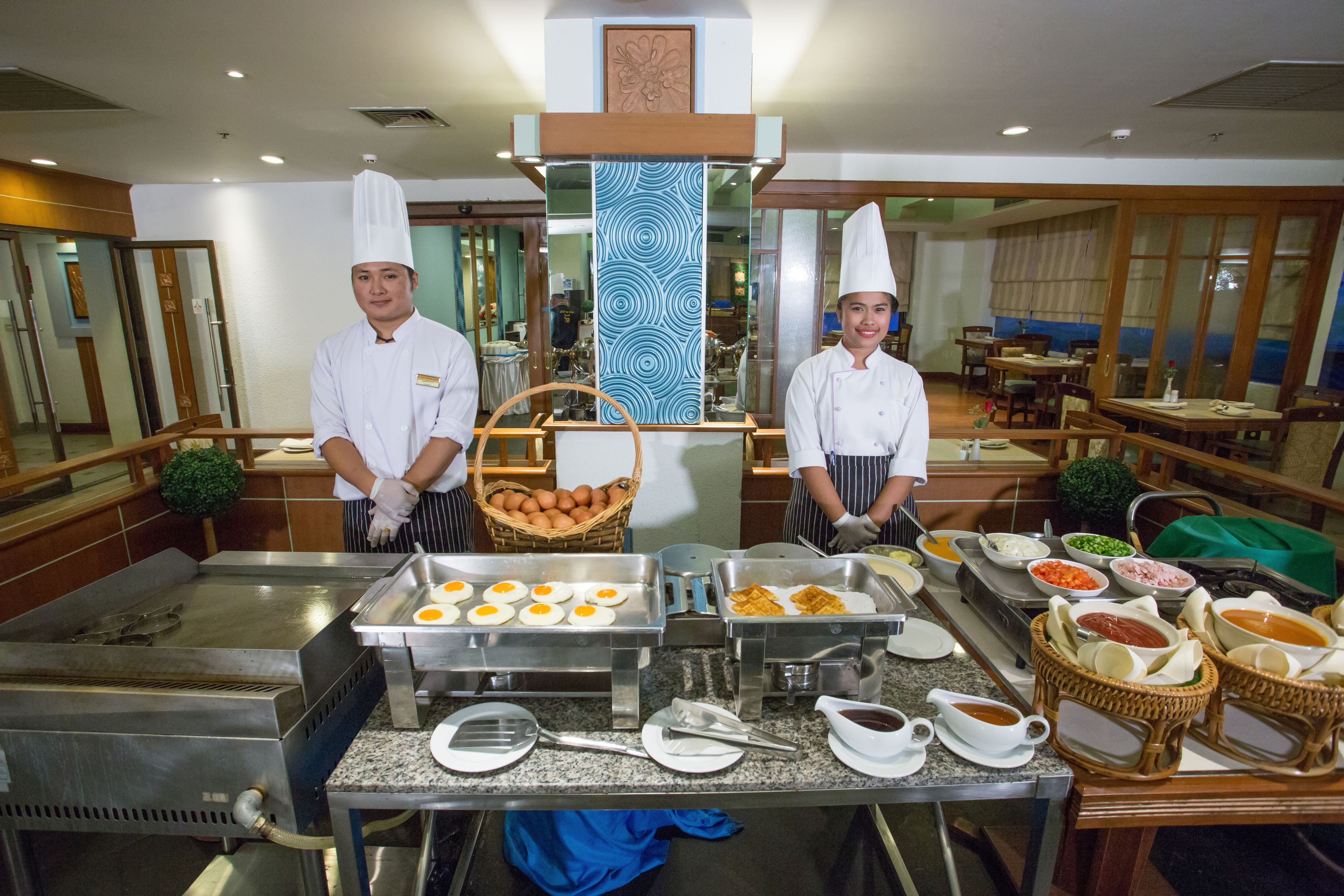 A buffet setup with various food items and serving utensils.