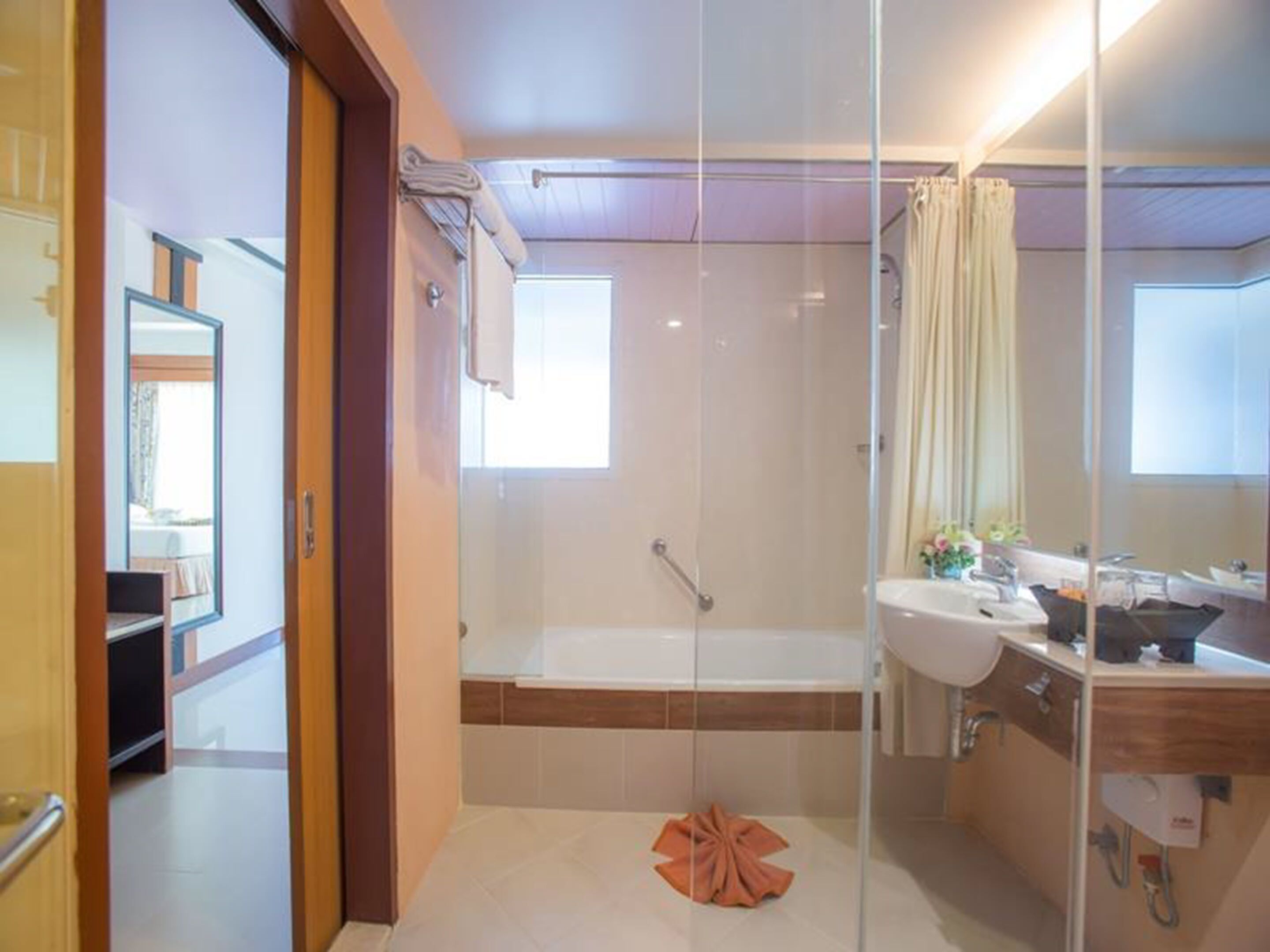 A modern bathroom with a glass shower enclosure, a bathtub, and a vanity with a sink.