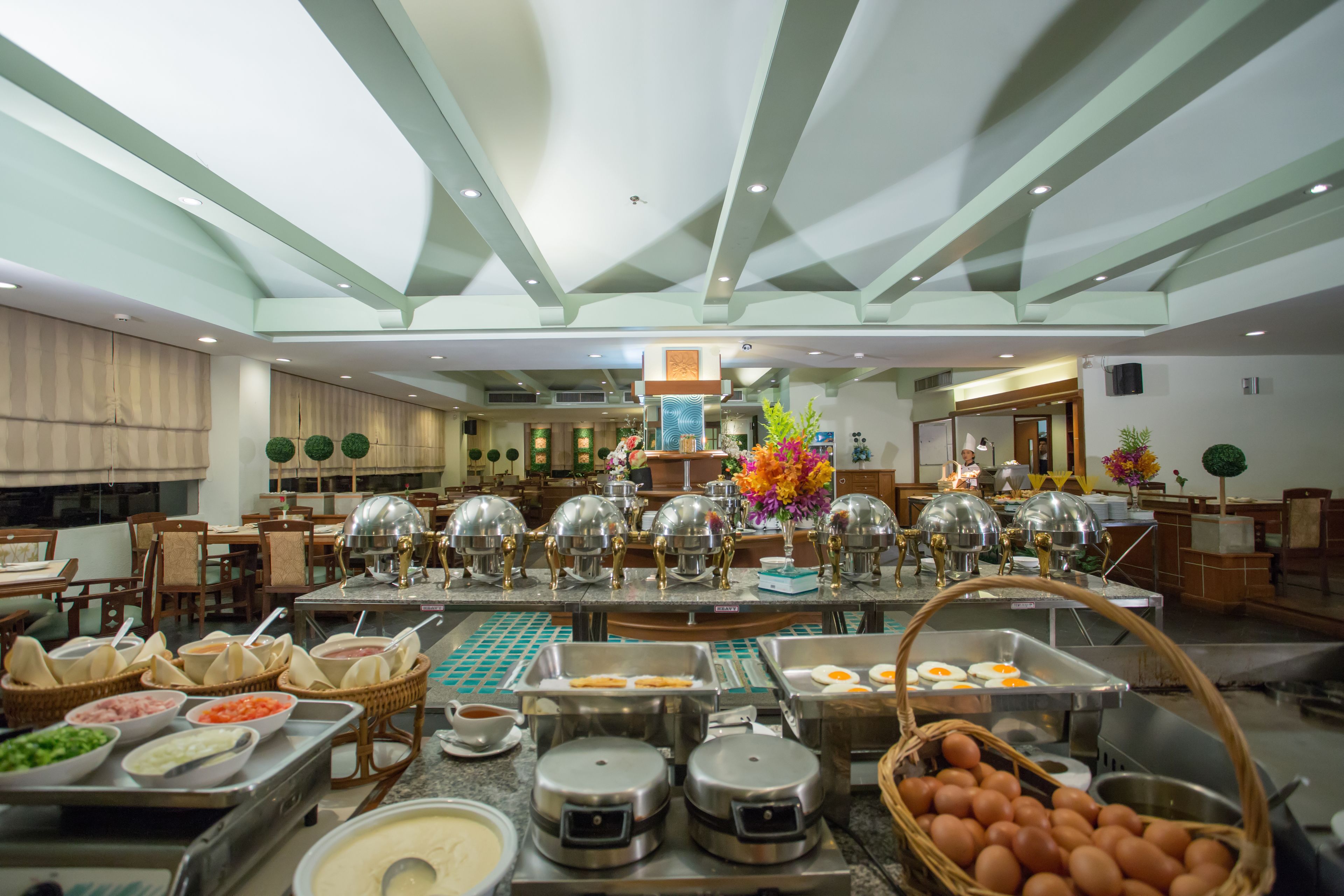A buffet setup with various food stations, including a section with eggs and a section with a variety of sauces and condiments.