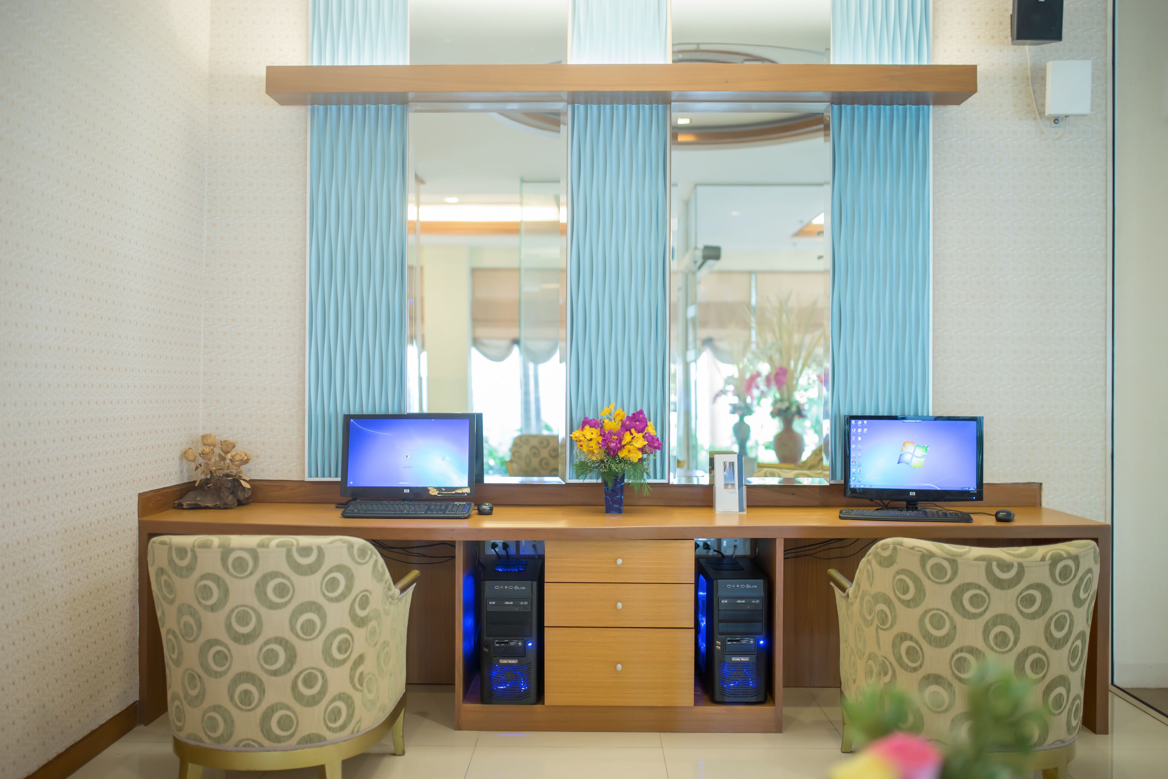 Un bureau moderne, équipé de deux ordinateurs, de deux chaises et de deux serveurs placés sous le bureau.