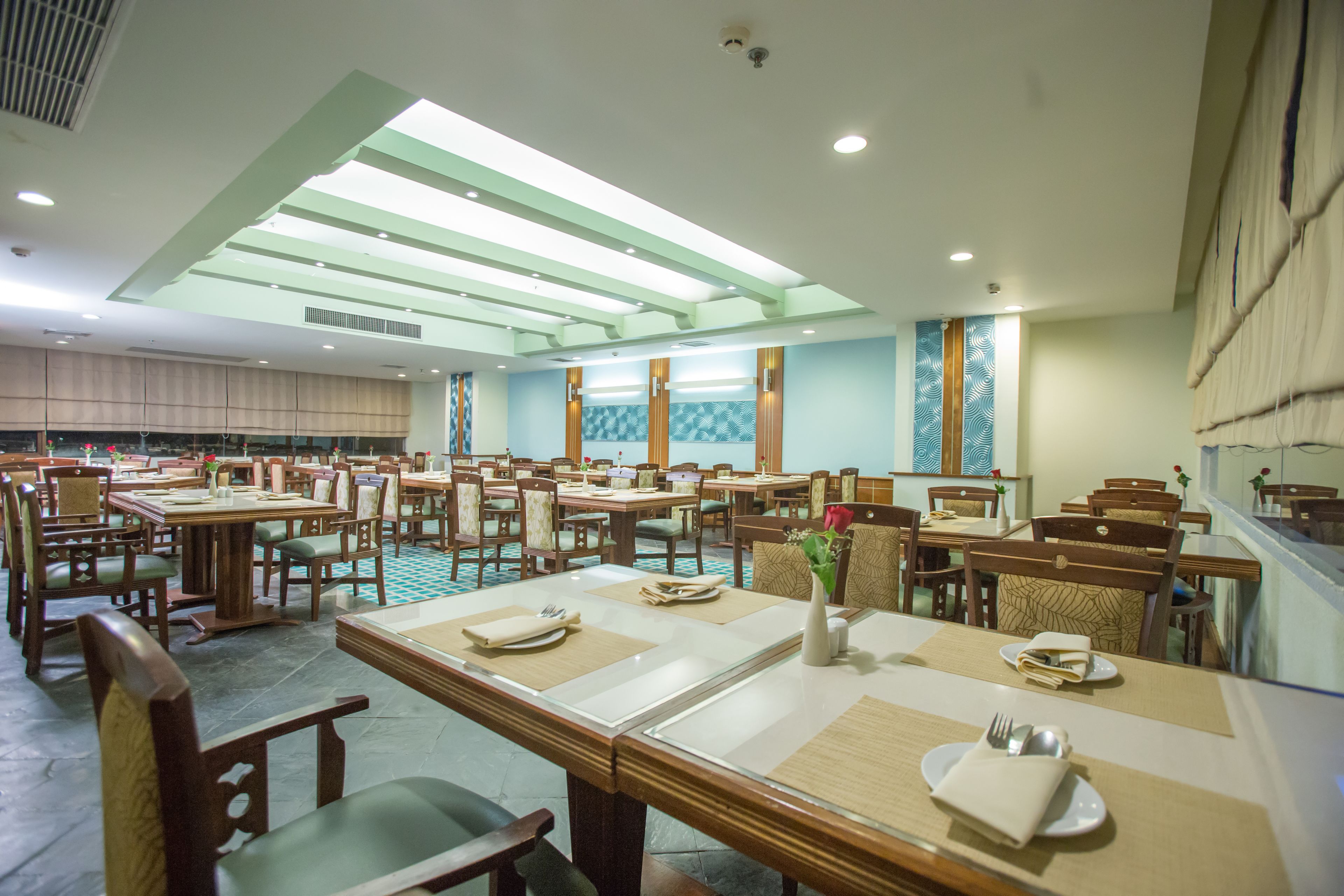 A spacious dining area with multiple tables and chairs, arranged in a grid pattern.