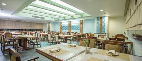 A spacious dining area with multiple tables and chairs, arranged in a grid pattern.