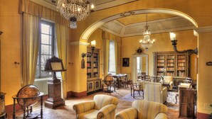 Eine Bibliothek mit Bücherregalen, einem Globus und einer Chandelüster.