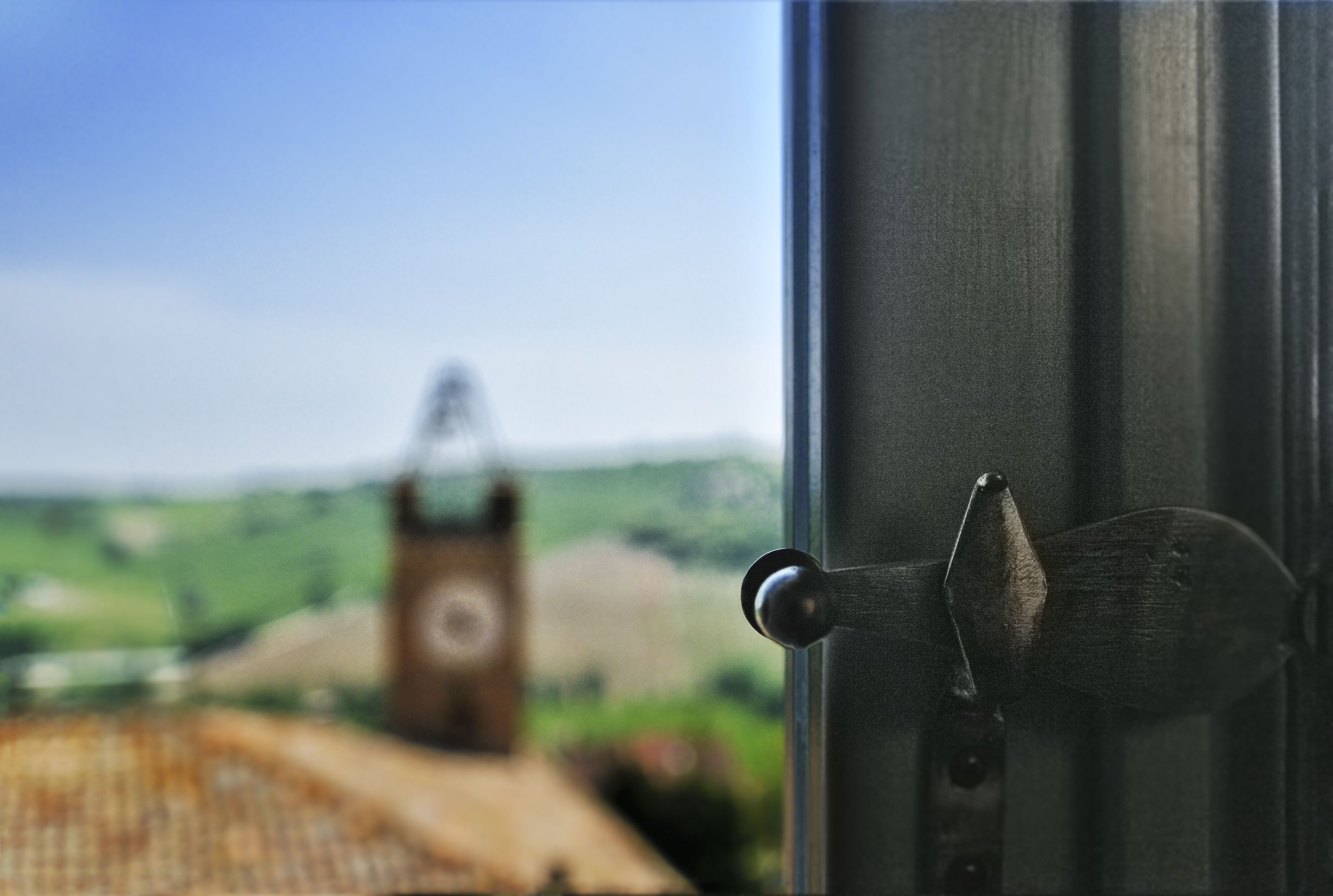 Eine Tür mit Blick auf einen im Hintergrund befindlichen Glockenturm.