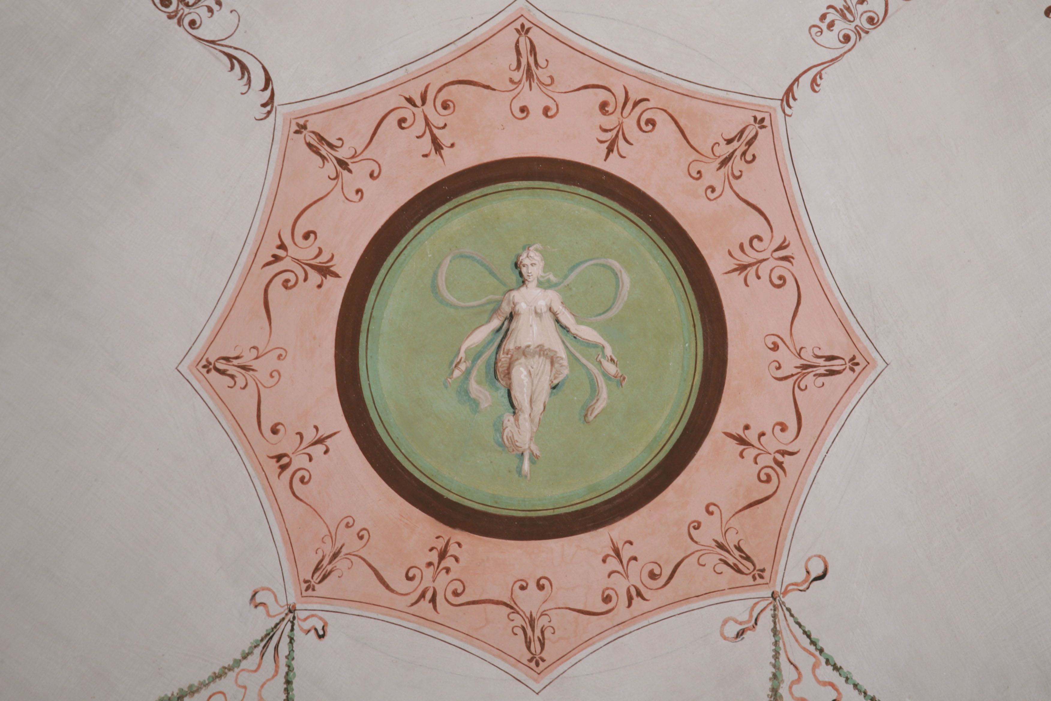 A ceiling with a decorative circular design featuring a central figure.