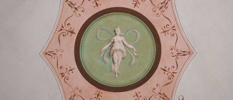 A ceiling with a decorative circular design featuring a central figure.