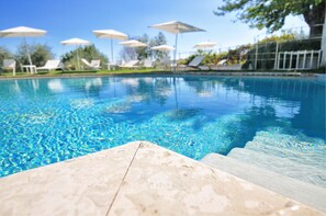 Piscine extérieure, parasols de plage, chaises longues