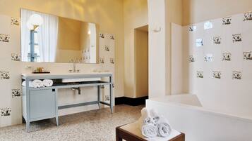 Ein Hotelbad mit Waschbecken, Spiegel, Handtuchhalter und Badewanne.