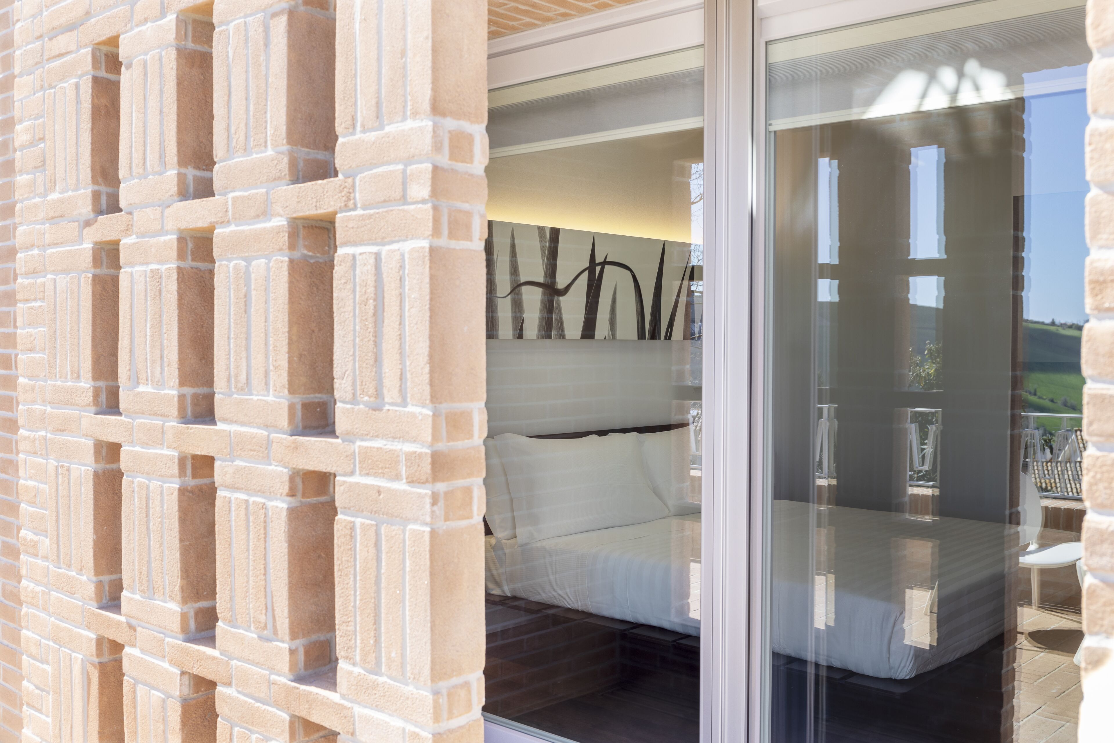 Un dormitorio con cama, ventana y vistas al exterior.