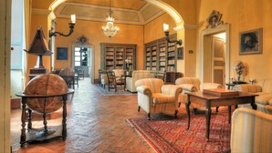 Eine Bibliothek mit Bücherregalen, einem Globus und bequemen Sitzgelegenheiten.