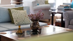 A living room with a sofa, a coffee table, and a decorative vase with flowers. - Casal do Frade (Sesimbra)
