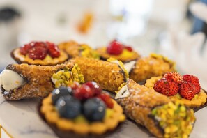A variety of pastries with fruits on a marble surface.