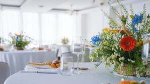 A table set with clear glasses, a pen, and a basket of flowers. - Hotel Le Rocce (Agerola)