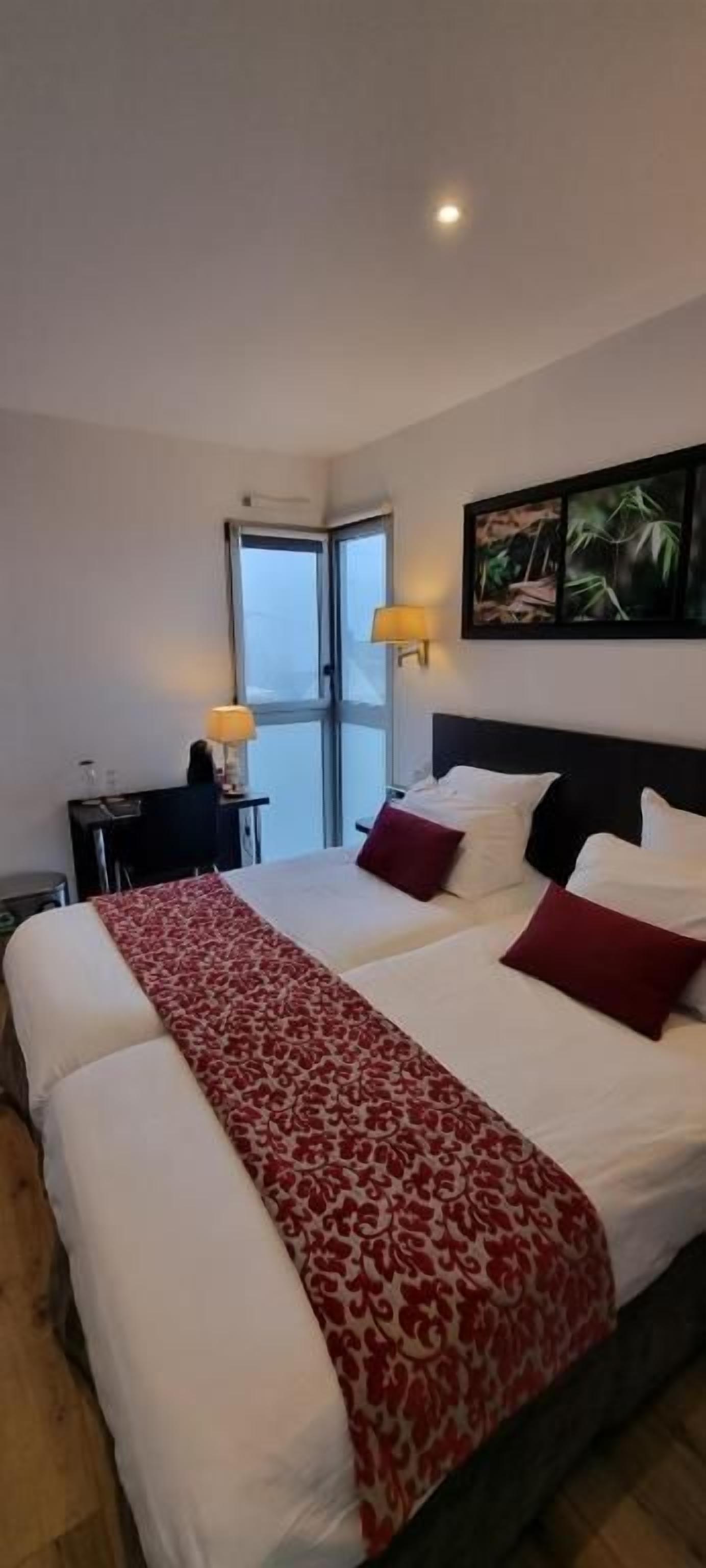 Habitación de hotel con una cama grande, un escritorio y una ventana.