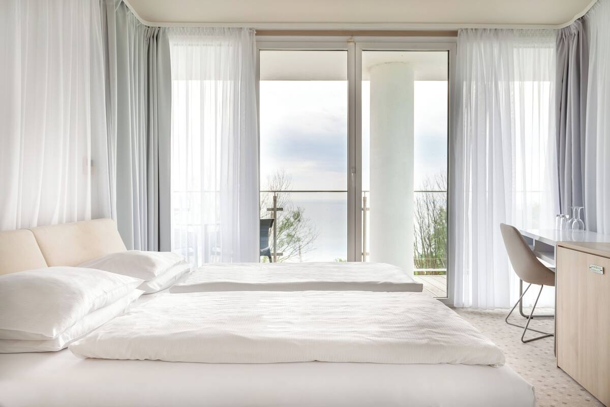 Habitación de hotel con una cama grande, un escritorio y vistas al exterior.