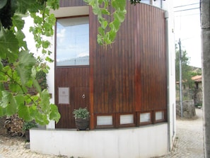 A building with a wooden exterior, a window, and a sign that reads "Casa da Escola." - A. Montesinho (Braganca)