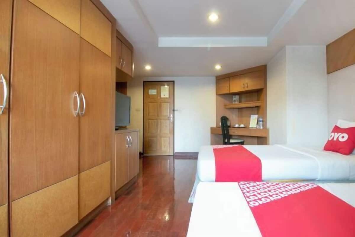 A hotel room with a bed, a wardrobe, a desk, and a television.