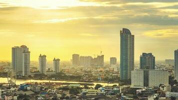A cityscape with high-rise buildings, a river, and a Ferris wheel.