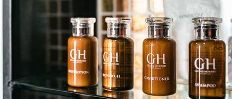 A bathroom shelf with four bottles of hair care products labeled 'GH'.