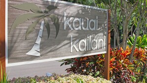 Un cartello con il nome 'Kauai Kōlanui' e una palma stilizzata.