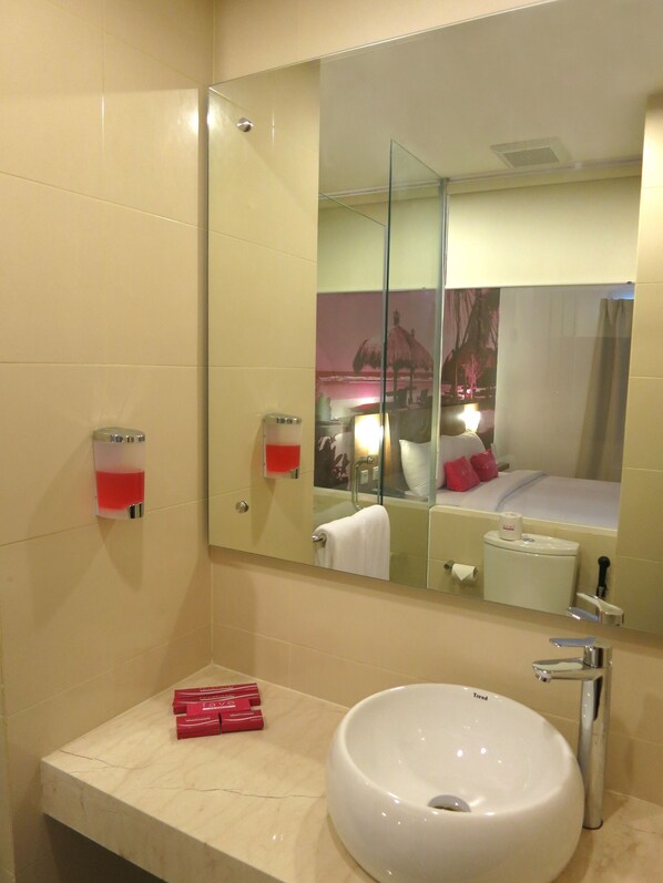 A bathroom with a large mirror, a white sink, and a towel rack.