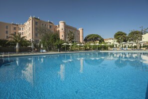 Una piscina al aire libre de temporada, tumbonas