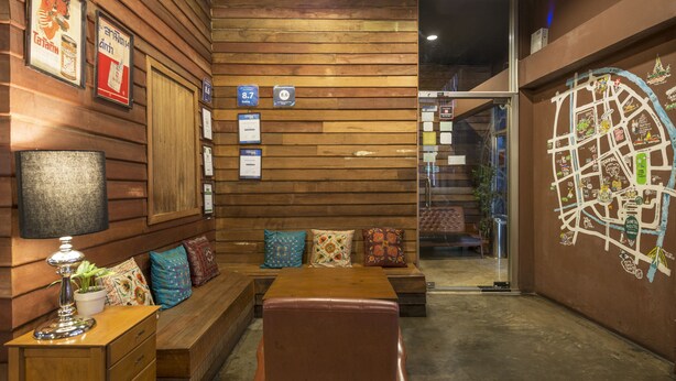 Una habitación acogedora con paneles de madera, un banco de madera, una mesa y un mapa en la pared.