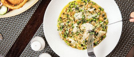 A plate of food with a fork on a textured tablecloth.
