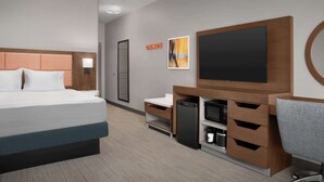 A modern hotel room with a bed, a desk, a flat-screen TV, a microwave, and a coffee maker. - Hampton Inn & Suites Williston (Williston)