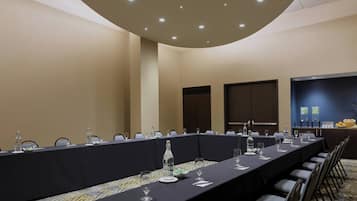 A conference room with a long table, chairs, and a buffet area.