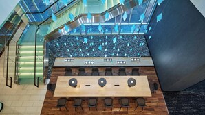 A modern conference room with a long table, chairs, and a stone wall backdrop. - SpringHill Suites by Marriott Denver Downtown (Denver)
