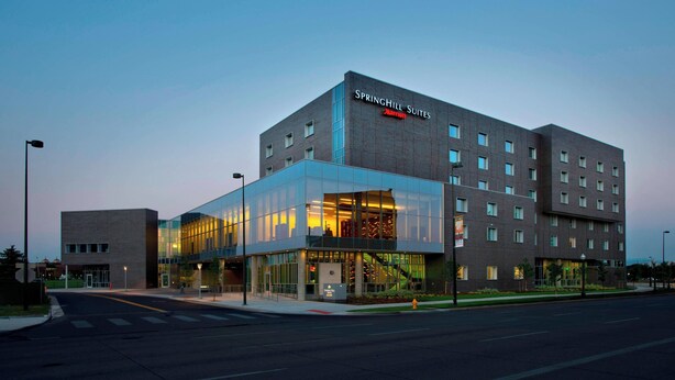 A modern hotel with a glass facade, multiple floors, and a prominent signage for SpringHill Suites. - SpringHill Suites by Marriott Denver Downtown (Denver)