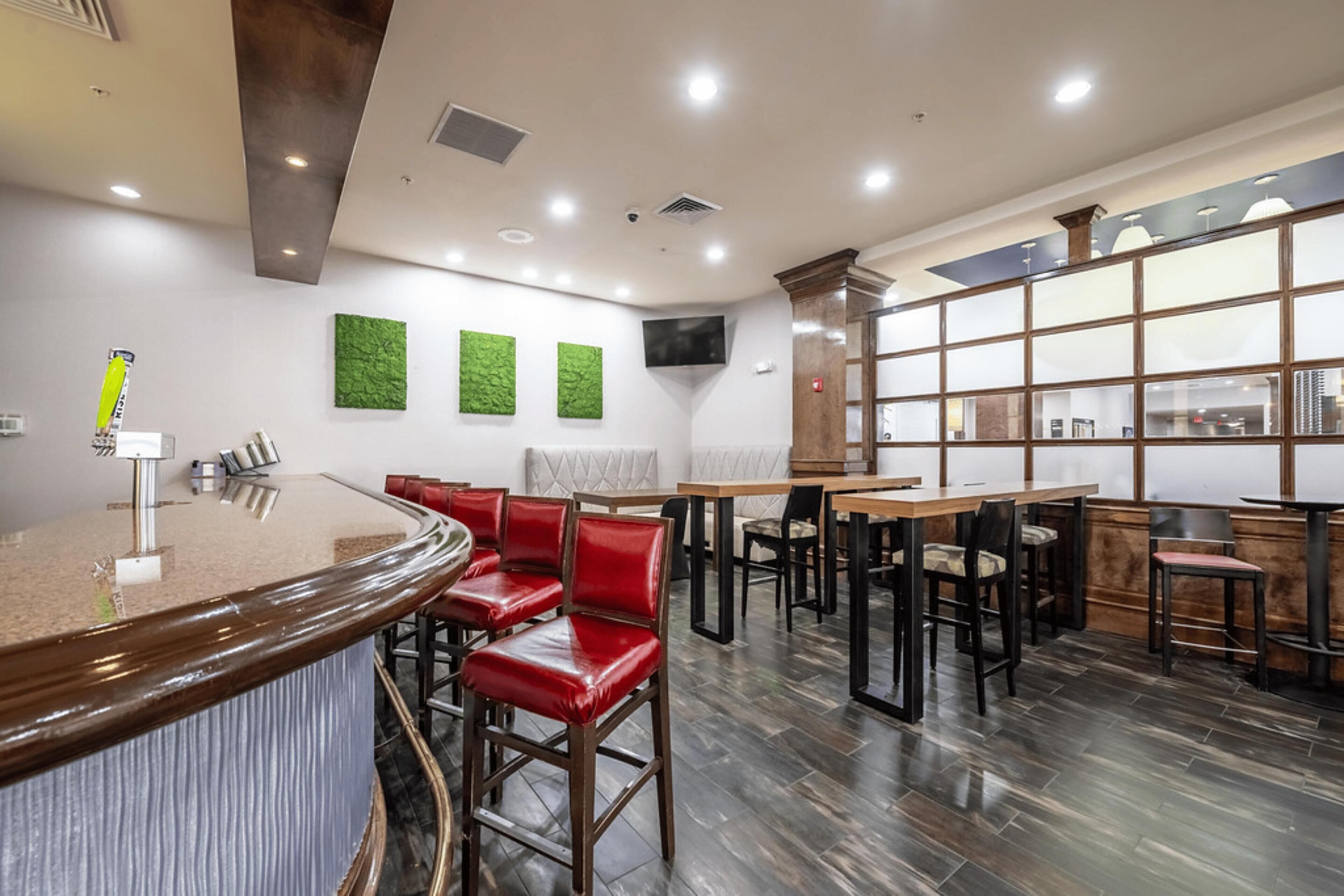 Un restaurant moderne doté d’un bar, de plusieurs espaces de restauration et d’une grande fenêtre offrant une vue panoramique.