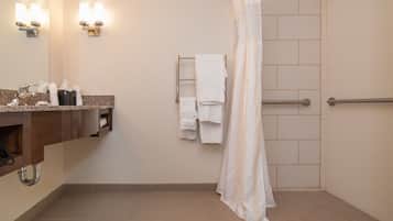 Une salle de bain équipée d’un lavabo, d’un miroir, d’un porte-serviettes et d’un rideau de douche.