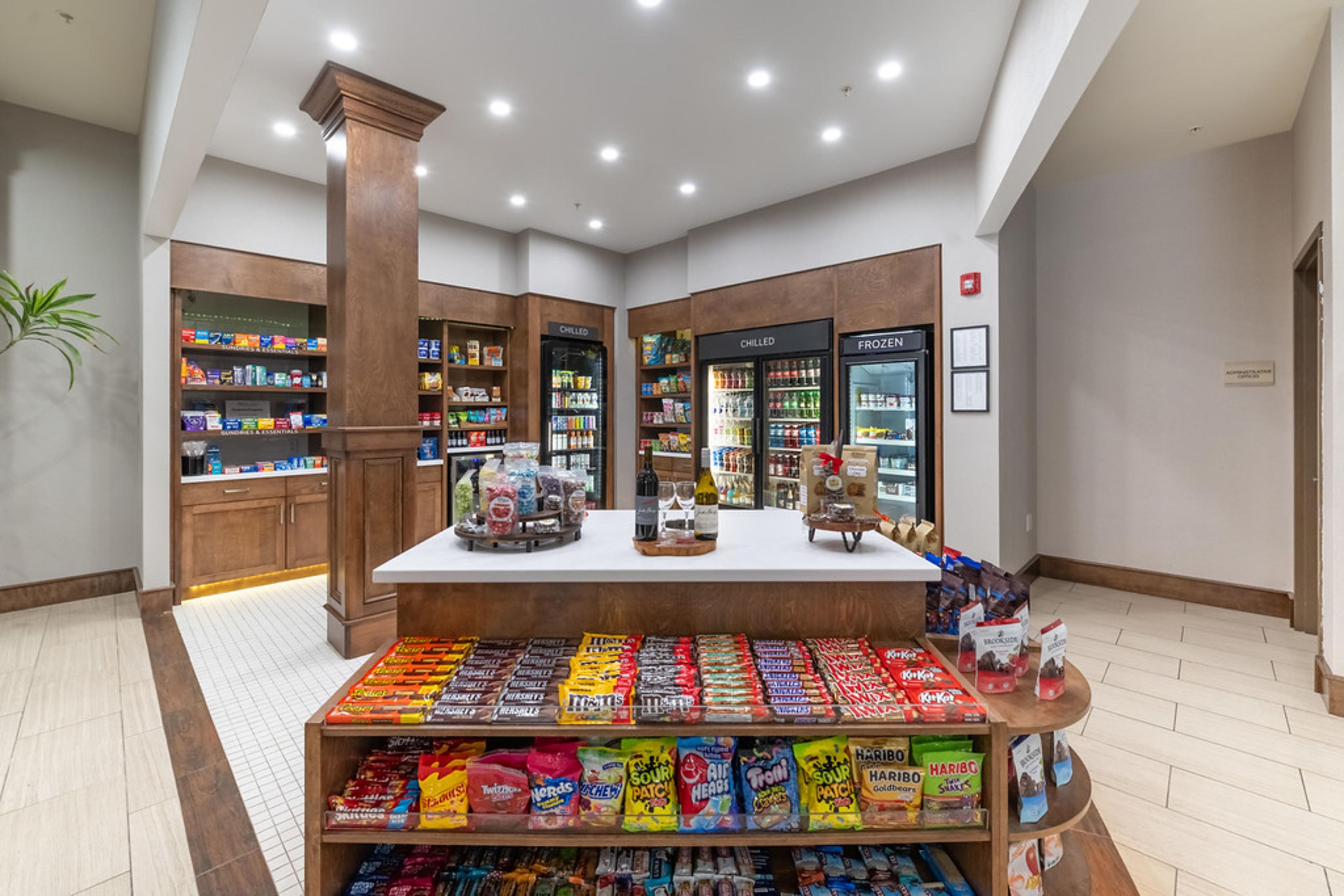 A candy display in a store with shelves and refrigerated sections.