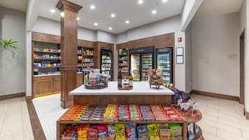 A candy display in a store with shelves and refrigerated sections.