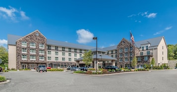 A multi-story hotel with a stone facade, a central courtyard, and a flagpole.