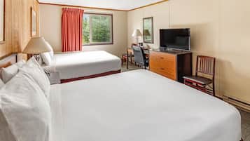 A hotel room with a large bed, a desk with a chair, a television, and a window with curtains.