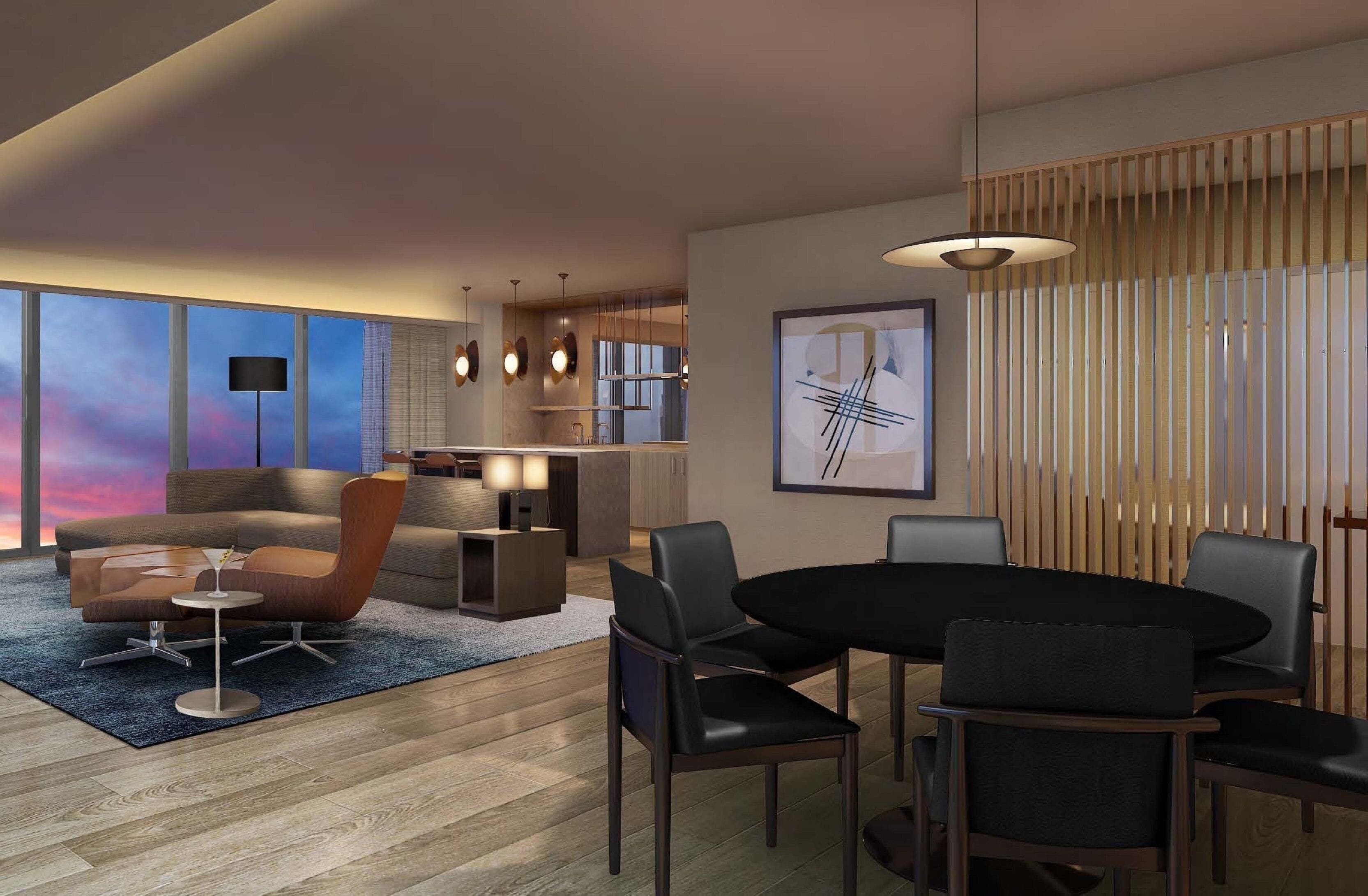 A modern living room with a sofa, coffee table, and dining area with chairs. There is a large window with a view of the sky.