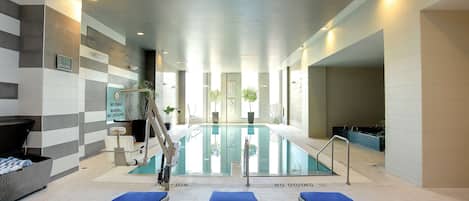A swimming pool area with lounge chairs and a no diving sign.