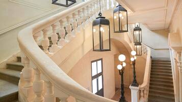A grand staircase with ornate balustrades and hanging lanterns.