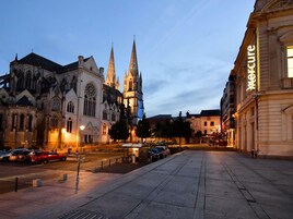 Une cathédrale à deux flèches et un grand bâtiment sur lequel on peut lire l’inscription « Mercure ».