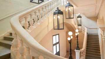 A grand staircase with ornate balustrades and hanging lanterns.