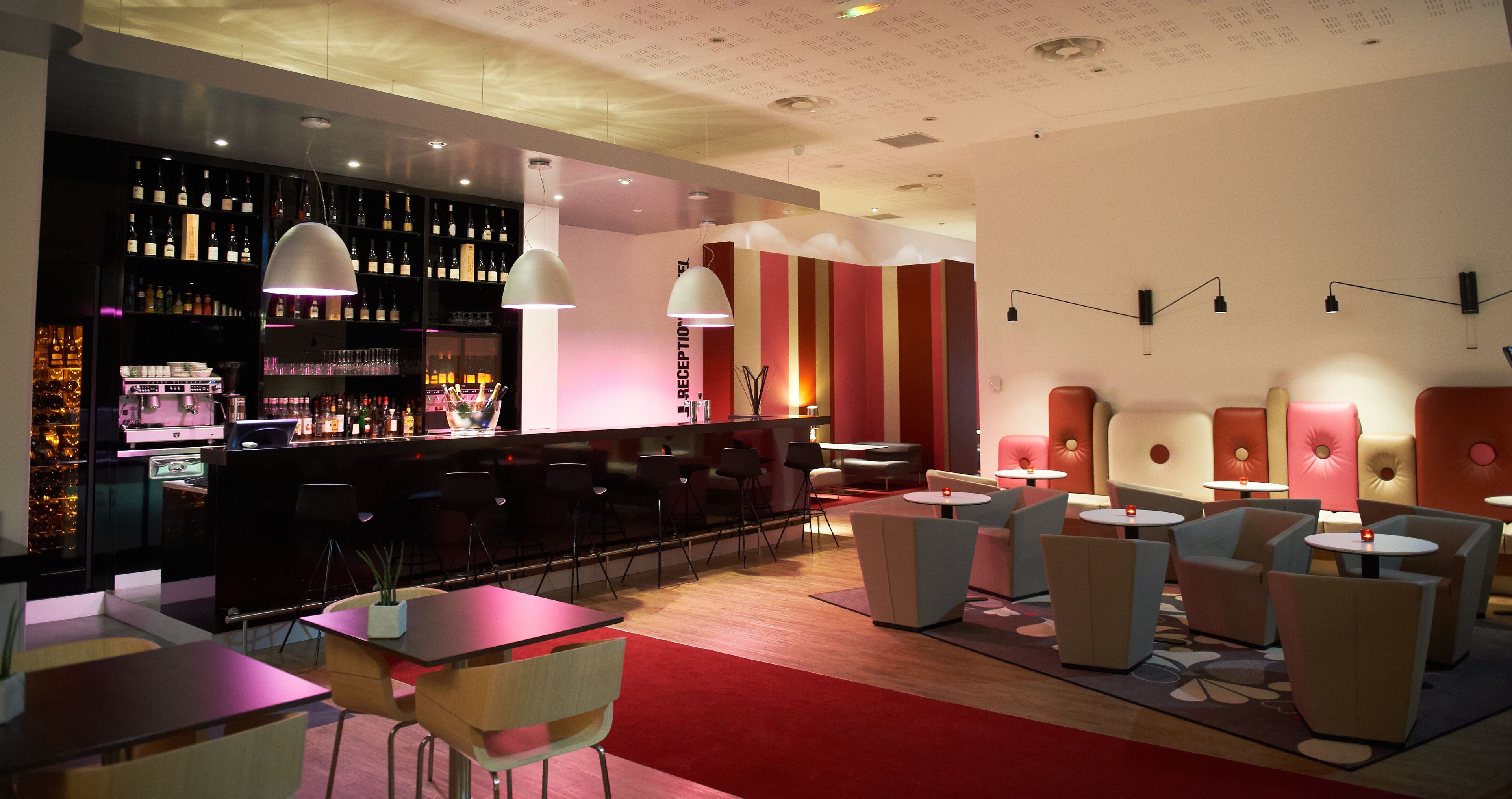 Zona de bar moderna con asientos y una barra.